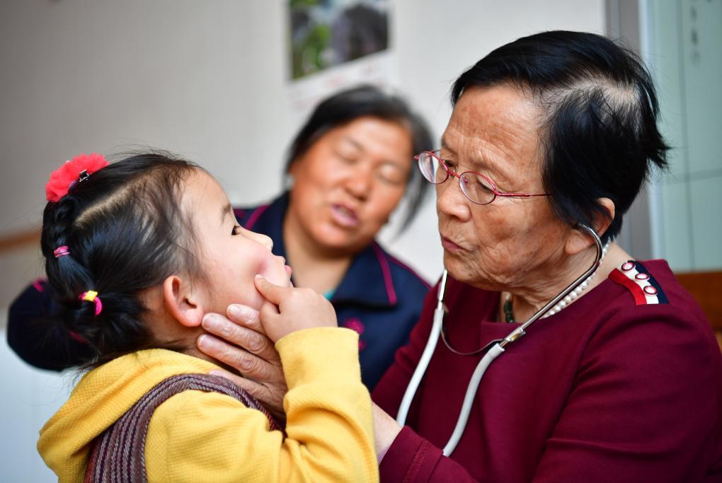 2018年4月29日，路生梅（右一）在家中給一名小朋友看病。新華社記者 邵瑞 攝