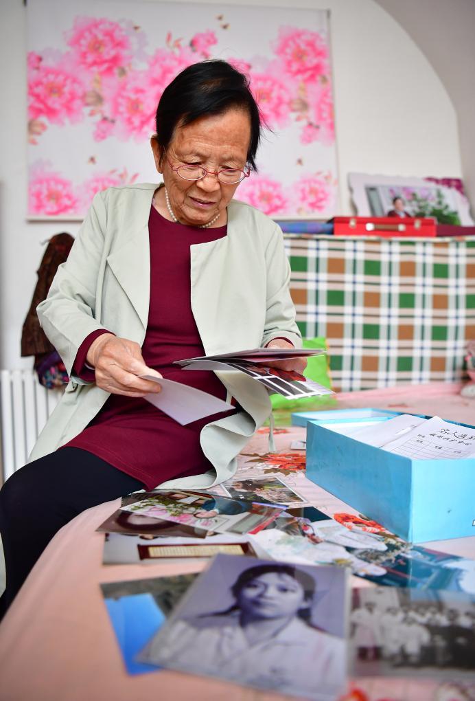 2018年4月29日,路生梅在家中翻看她年輕時(shí)候的照片。新華社記者 邵瑞 攝