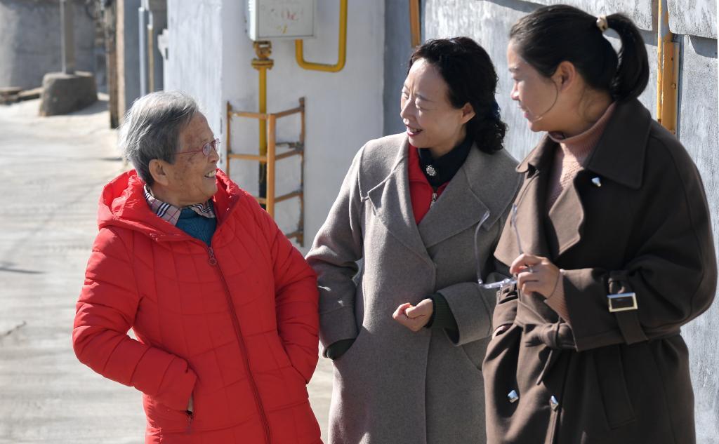 在陜西省榆林市佳縣，路生梅與志愿服務機構的工作人員聊天（2022年11月15日攝）。新華社記者 鄒競一 攝